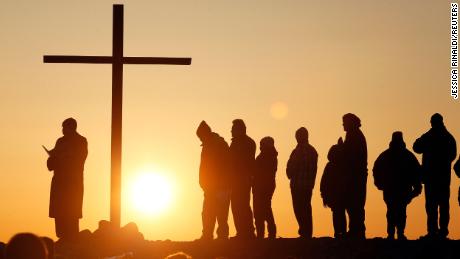 People are silhouetted as the sun rises during an Easter sunrise service in Scituate, Massachusetts March 31, 2013. REUTERS/Jessica Rinaldi (UNITED STATES - Tags: RELIGION SOCIETY)