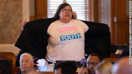 Rep. Heather Meyer shows her &quot;protect trans youth&quot; t-shirt to legislature members following Wednesday&#39;s vote to override Gov. Laura Kelly&#39;s veto of an anti-trans sports bill. 