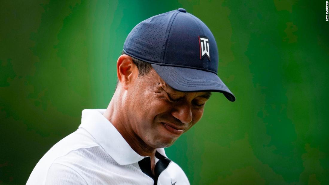 Woods grimaces on the fourth tee Thursday. The five-time Masters champion said his surgically repaired right leg felt sore Thursday and that the pain is &quot;constant.&quot;