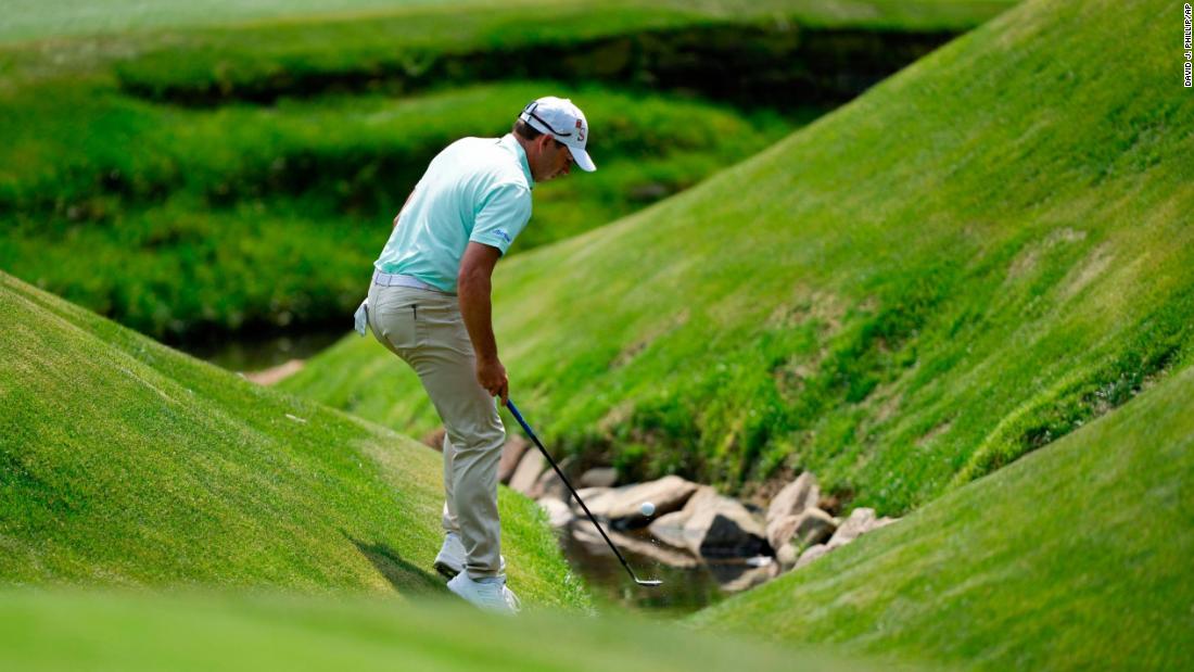 Sergio Garcia fishes his ball out of the creek on No. 13.