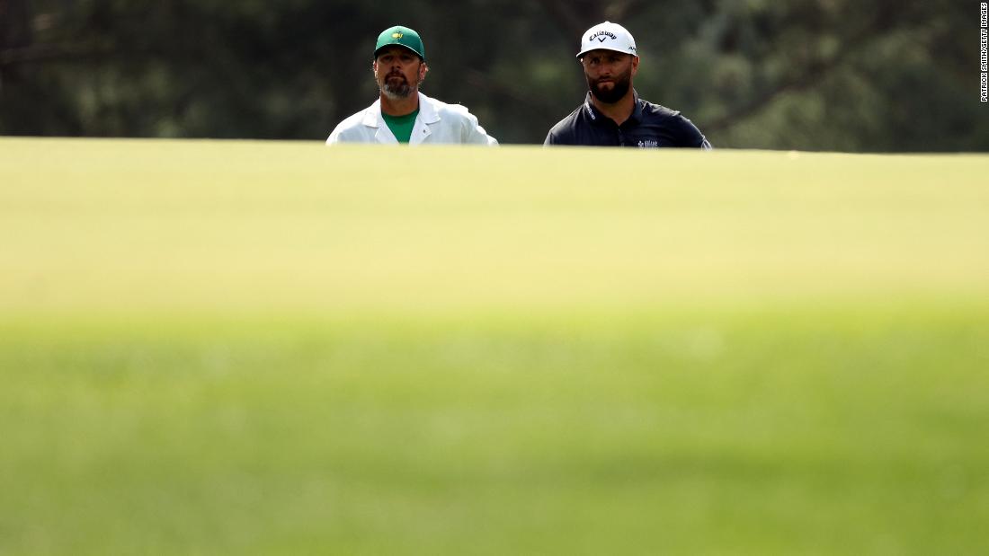 Rahm and his caddie, Adam Hayes, are seen on the third green Thursday.