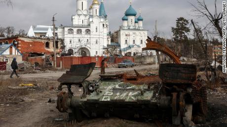 A local resident walks past a damaged church and a destroyed Russian tank in the town of Svyatogirsk, Donetsk region, on March 1, 2023. 
