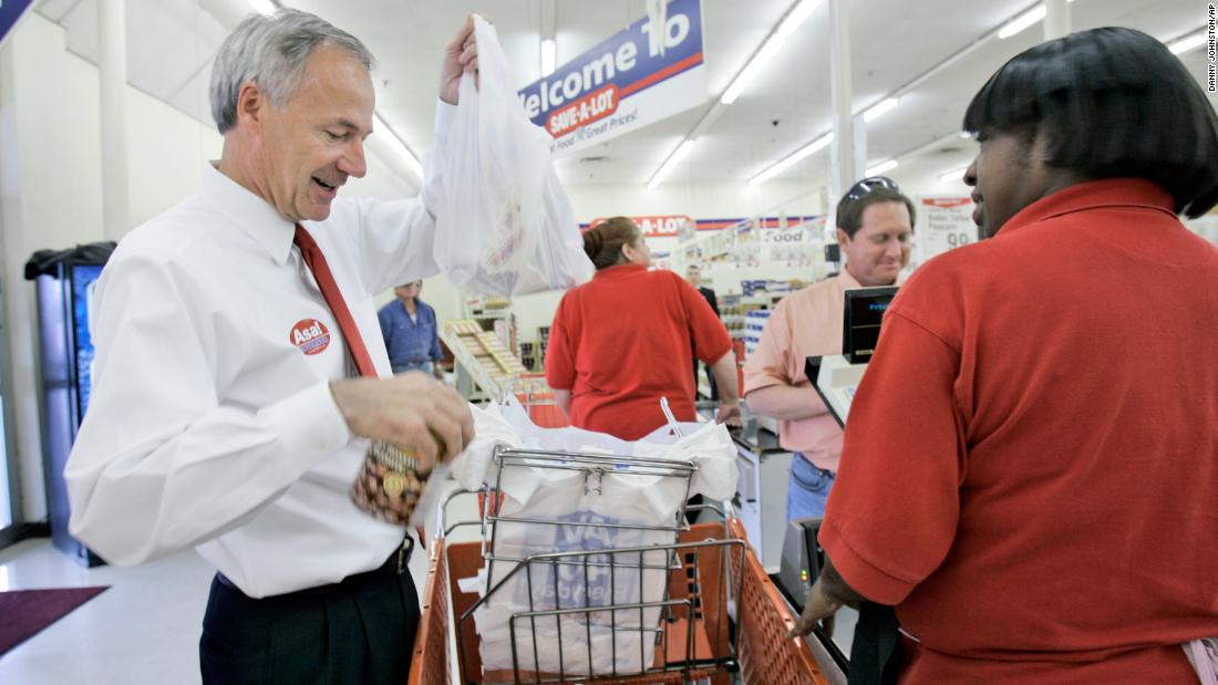 Hutchinson bags food for a customer in Little Rock, Arkansas, while campaigning for governor in October 2006. He was promoting the elimination of a state sales tax on groceries.