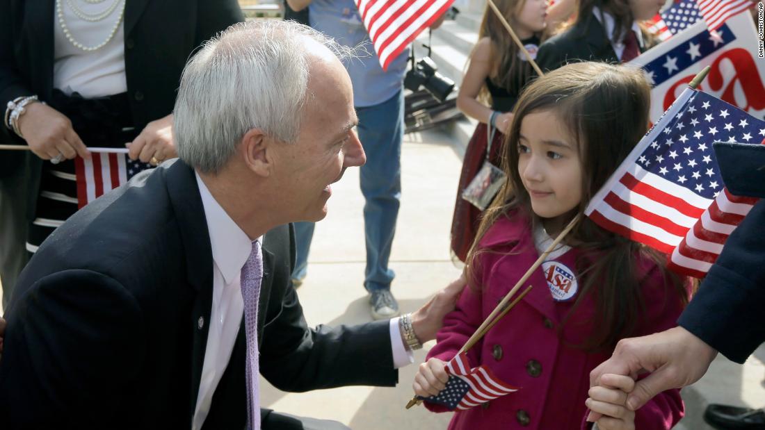 Hutchinson, running for governor again, talks to 5-year-old Addison Mhoon after a speech at the Arkansas State Capitol in February 2014.