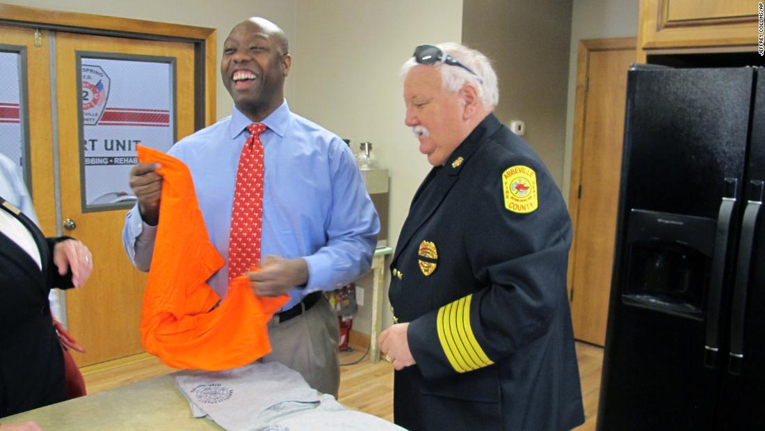 Scott accepts a T-shirt from Abbeville County Fire Marshal Dan Edatt during a visit in August 2013. Scott was finishing up a tour of all of South Carolina&#39;s 46 counties. He won an election the next year to serve the final two years of DeMint&#39;s term.