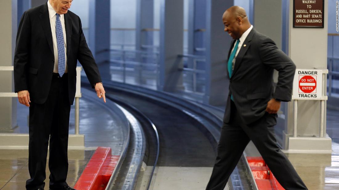 US Sen. Richard Shelby points to an electrified rail as Scott steps across the Senate subway track in August 2018.