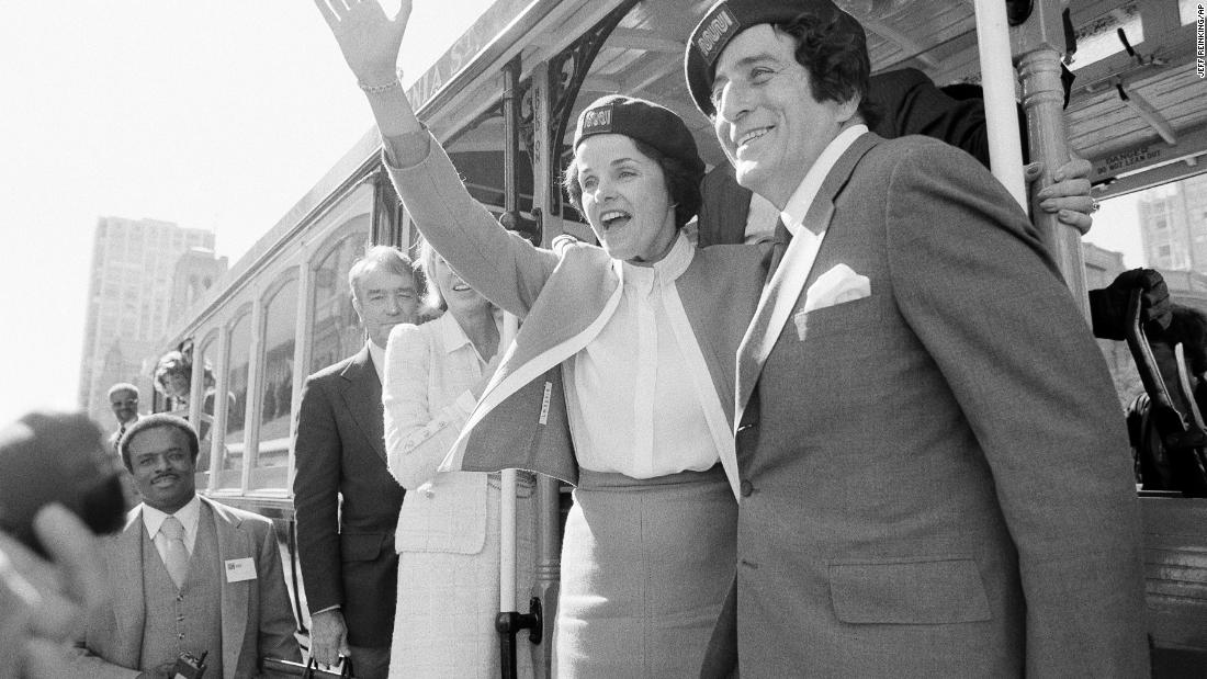 Feinstein and singer Tony Bennett wave from a cable car in San Francisco before taking a test ride in 1984.