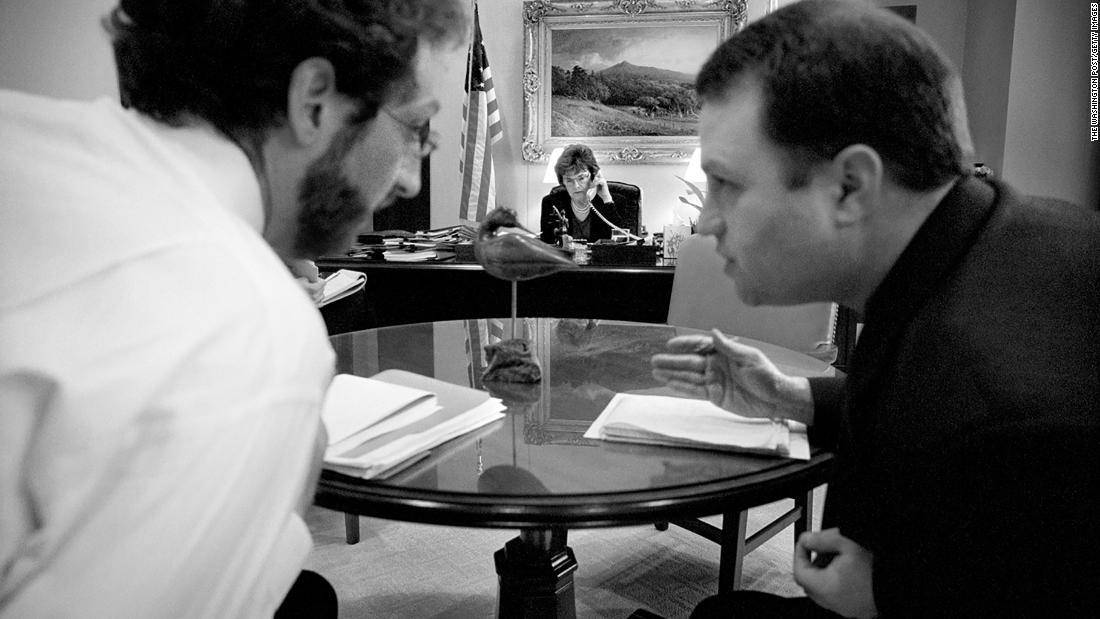 In 2003, Feinstein speaks to a fellow senator on the phone as two of her staffers talk in the foreground.