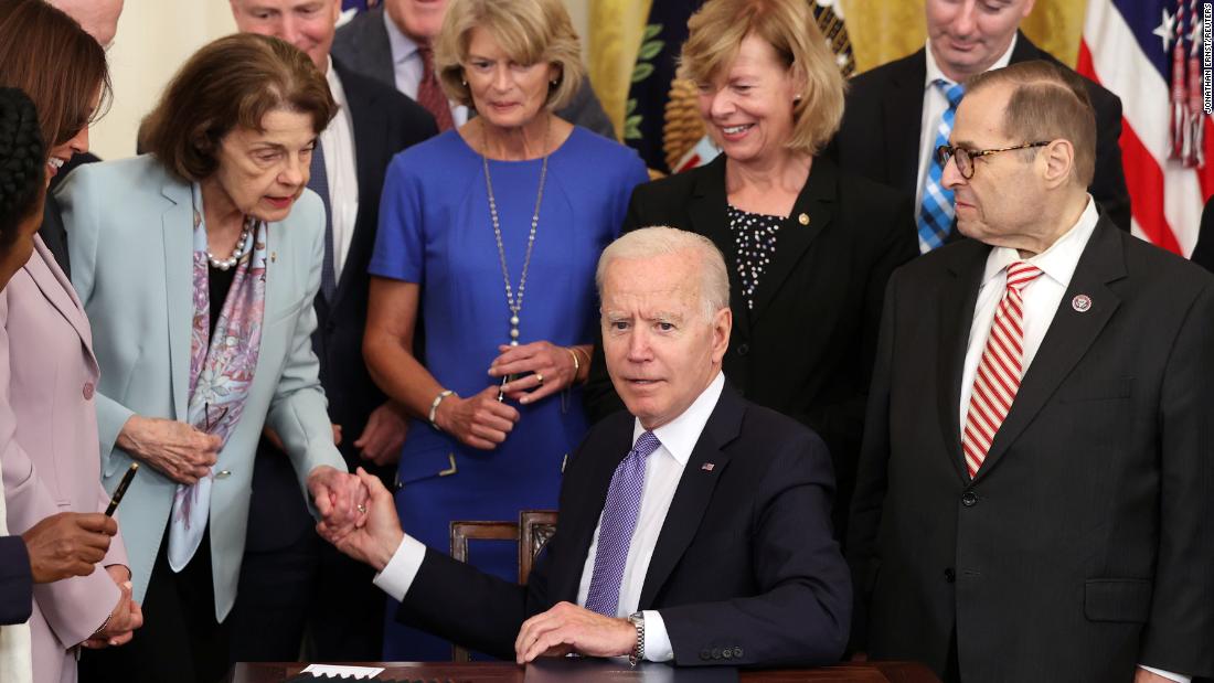 President Joe Biden holds Feinstein&#39;s hand after signing into law the Victims of Crime Act in the East Room at the White House in 2021.