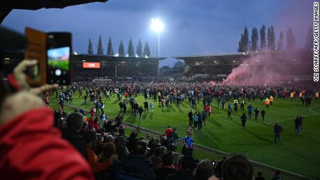 Wrexham&#39;s fans celebrate on the pitch after the club won the title. 