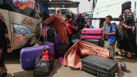 Passengers fleeing war-torn Sudan disembark at a bus station near the Egyptian city of Aswan, on April 25, 2023.