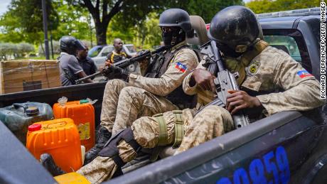 Haitian police collect fuel as they patrol in Port-au-Prince on July 15, 2022. 