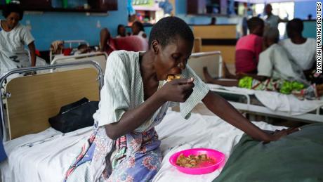 A survivor and a follower of Mackenzie&#39;s eats a meal inside a ward at the Malindi sub district hospital in April. 