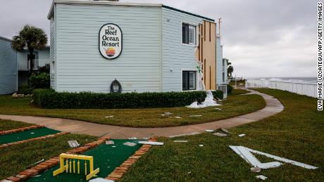Siding hangs from building in November 2022 at The Reef Ocean Resort in Vero Beach, Florida, after Hurricane Nicole made landfall.