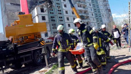 Rescuers carry the body of a victim found under the rubble at a block of flats destroyed in a Russian rocket attack on Uman, in central Ukraine&#39;s Cherkasy region, on April 28, 2023.