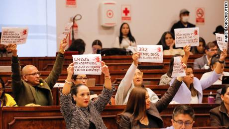 Opposition assembly members hold up signs in protest to the country&#39;s problems such as migration, health crisis, femicide and increased violence during a hearing in Quito on April 26.