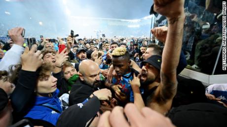 Osimhen is surrounded by Napoli fans after the team wins the Serie A title.
