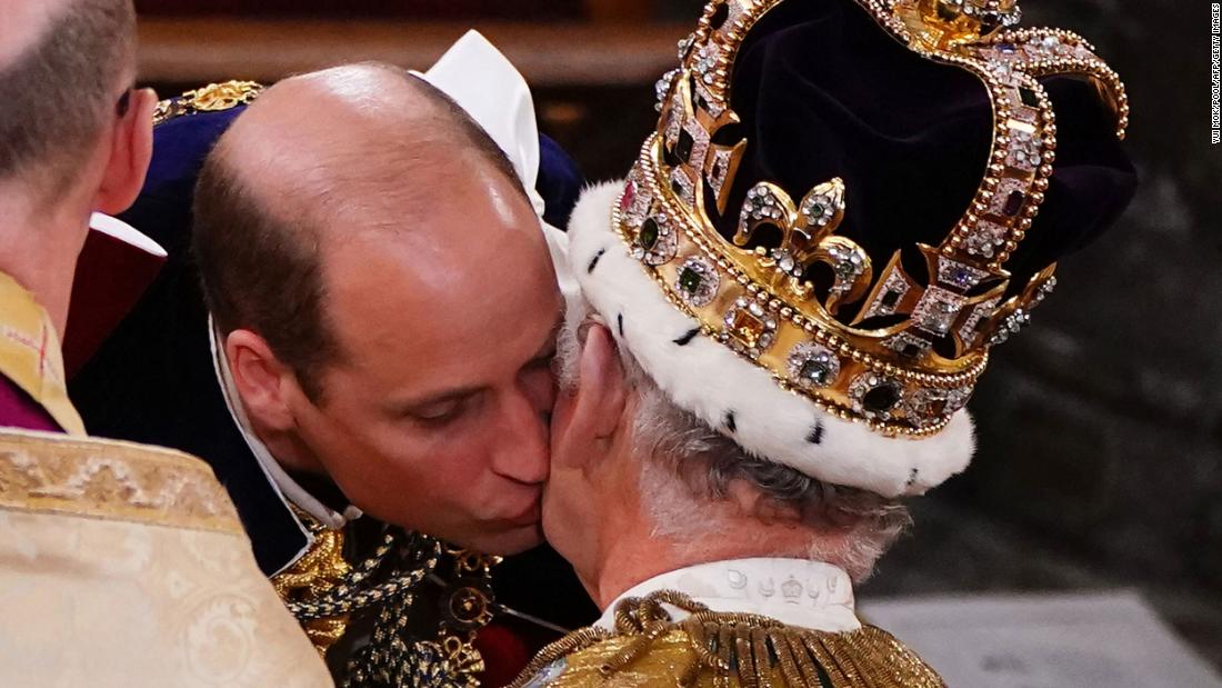 The King&#39;s son Prince William, the heir apparent to the throne, kisses his father on the cheek during the ceremony.