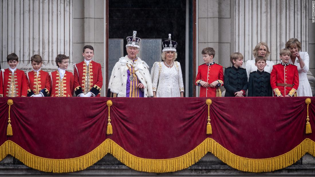 The King and Queen stand on the balcony of Buckingham Palace after the coronation. They are joined here by pages of honor who attended them throughout the day. One of the pages was the King&#39;s eldest grandson, Prince George, who can be seen second from left.