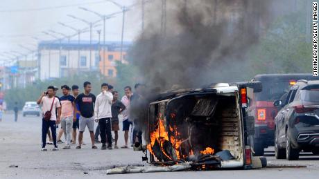 In this picture taken on May 4, 2023, smoke billows from a vehicle allegedly burned by the Meitei community tribals protesting to demand inclusion under the Scheduled Tribe category, in Imphal the capital of India&#39;s Manipur state.