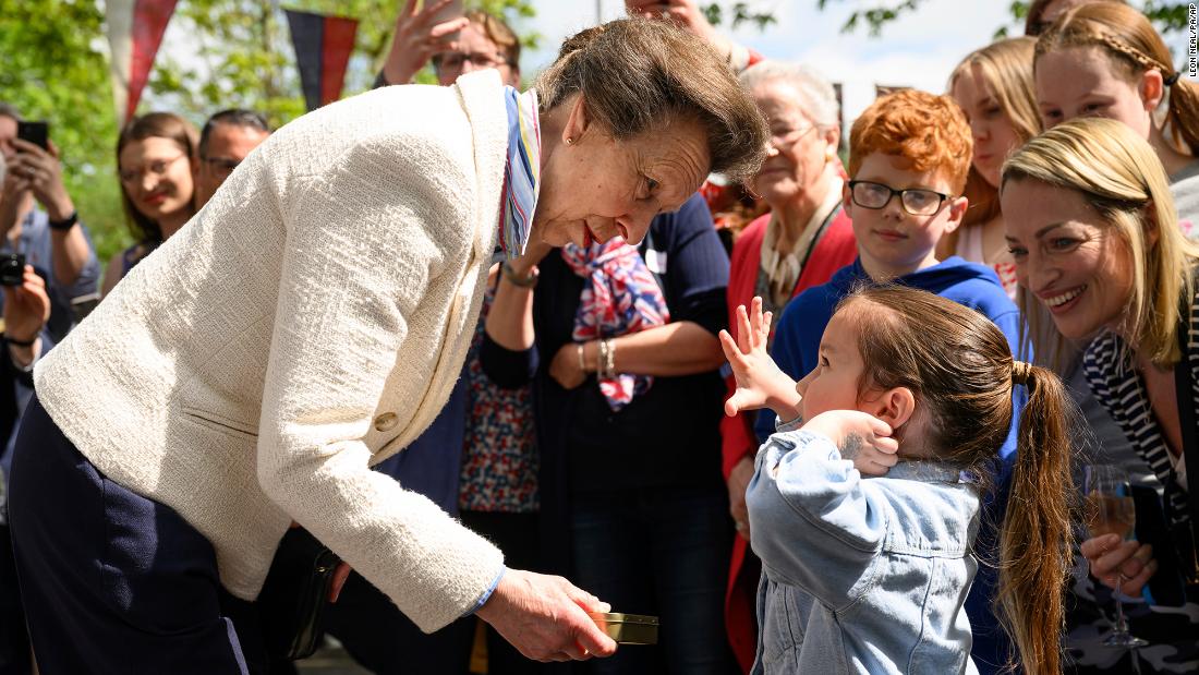 Princess Anne, the King&#39;s sister, presents a young girl with a commemorative tin of old coins during celebrations in Swindon, England.
