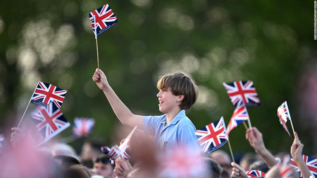 The crowd inside the Windsor Castle grounds waves flags as Sunday&#39;s &quot;Coronation Concert&quot; gets underway.