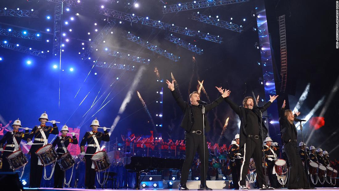 Gary Barlow, Howard Donald and Mark Owen of &#39;90s British pop group Take That perform backed by military drummers.