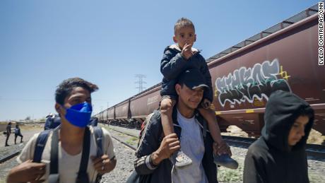 Cold, hungry and determined: Families climb freight trains to reach US border