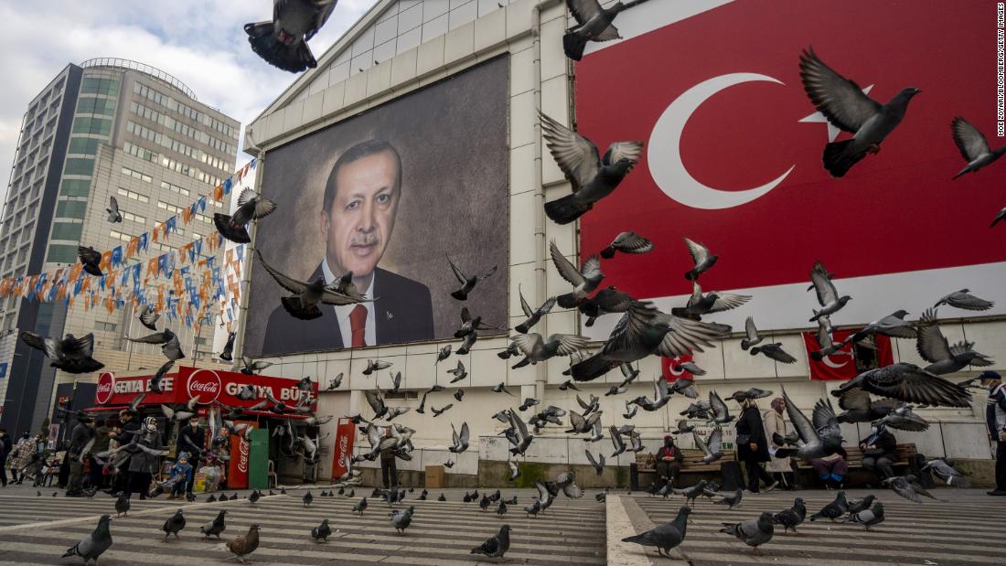 Pigeons take flight in front of a mural of Erdogan in Bursa, Turkey, in January 2022.