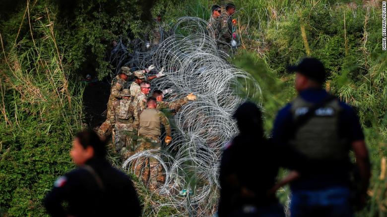 Texas National Guard soldiers place more razor wire on the banks of the Rio Grande in Matamoros on May 11.