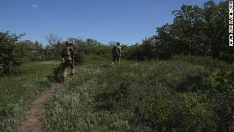 Ukrainian soldiers use the forest foliage as cover from Russian attacks on the outskirts of Bahkmut.