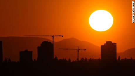 The sun sets over the University District in Seattle, Saturday, May 13, 2023. Saturday&#39;s temperatures reached record-breaking highs for several cities across western Washington.