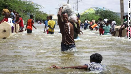 A man carries a sack through floodwater in Beledweyne, central Somalia. Flash flooding in central Somalia has killed 22 people and affected over 450,000, the UN&#39;s humanitarian agency OCHA said. 