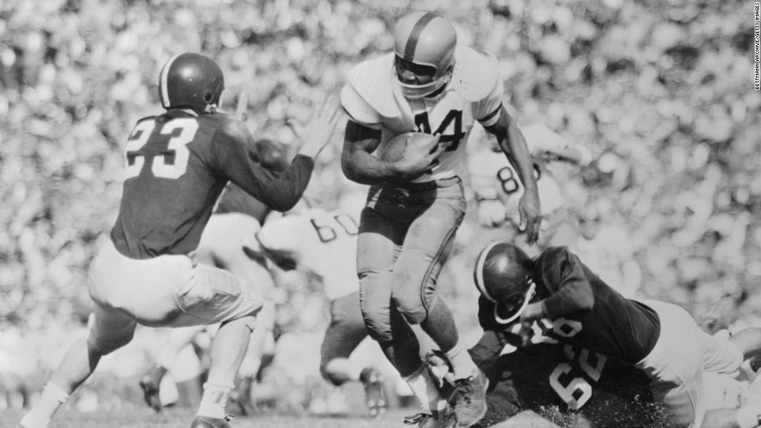 Brown plays football for Syracuse in the 1957 Cotton Bowl. Brown, a bruising fullback, rushed for three touchdowns in the game.