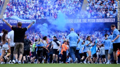 Manchester City fans invade the pitch after Sunday&#39;s 1-0 win against Chelsea, teh team&#39;s first match since winning the title. 