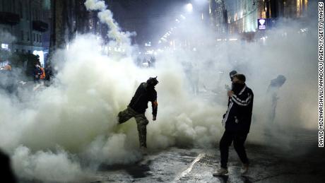 Demonstrators throw tear gas back at police during the &quot;foreign agent&quot; protests on March 8.