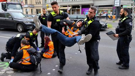 Police officers on May 16, 2023 carry away a climate activist from &quot;Letzte Generation&quot; (Last Generation), who had glued himself to a street in Berlin.
