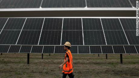 An ENGIE employee walks past solar panels at the ENGIE Sun Valley Solar project in Hill County, Texas, on March 1, 2023.