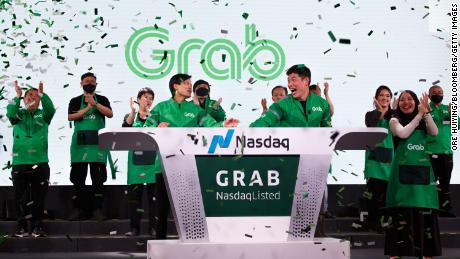 Grab&#39;s CEO, Anthony Tan, and co-founder Tan Hooi Ling, ring the bell as the Singapore-based company begins trading on the Nasdaq via a SPAC listing.