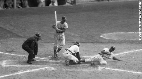In a file photo -- September 28, 1955 -- Jackie Robinson (R) is safe under an attempted out by Yankee catcher Yogi Berra, on a steal home from third. Pinch hitter Frank Kellert (L) waits to bat. The Yankees beat the Dodgers 6-5.