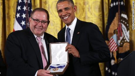 Larry Berra (L), son of baseball legend Yogi Berra, receives the Presidential Medal of Freedom on behalf of his father from US President Barack Obama (R) during an East Room ceremony November 24, 2015 at the White House in Washington, DC.