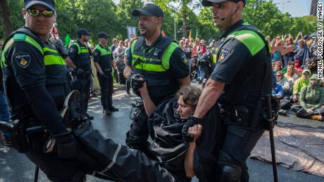 An activists is arrested after blocking the A12 motorway during an Extinction Rebellion led protest to command an end to all fossil fuel subsidies on May 27, 2023 in The Hague, Netherlands. 