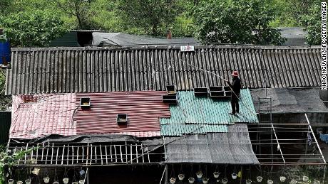 This photo taken on May 30 shows a woman watering her rooftop to cool it down in Hanoi, Vietnam.