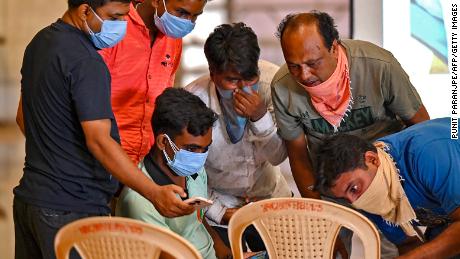 Family members look at photographs on a computer to identify bodies at a temporary mortuary following a train collision near Balasore, in India&#39;s eastern state of Odisha, on June 4, 2023. 