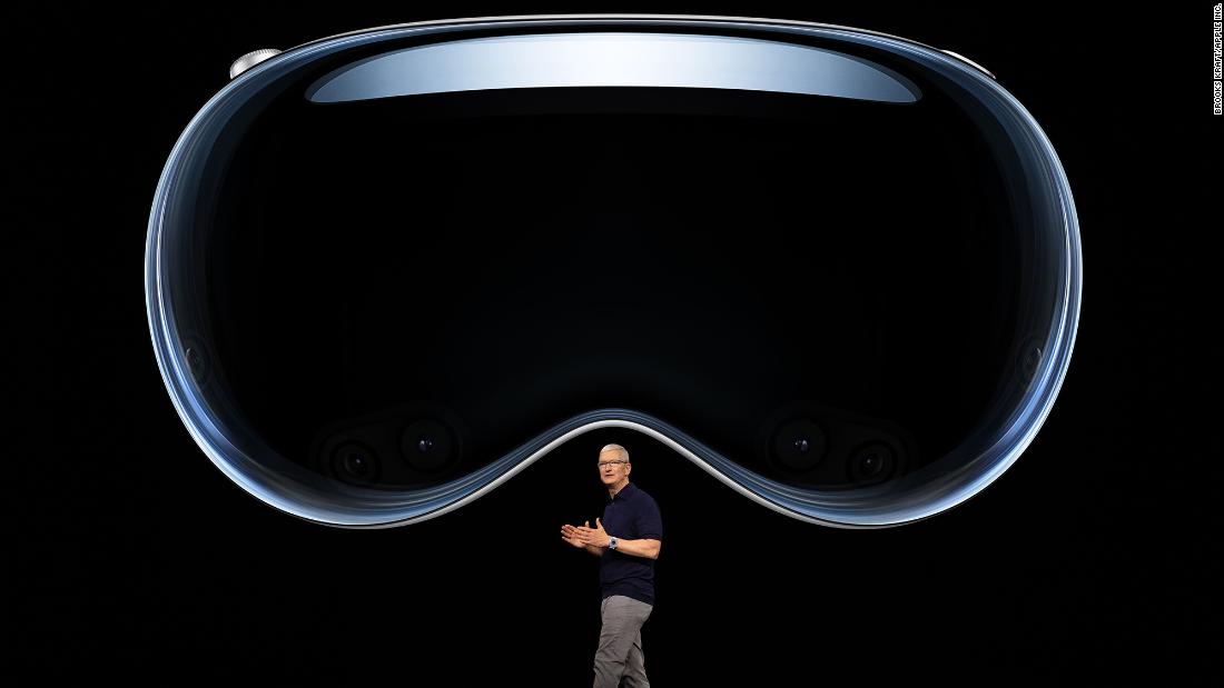 Cook speaks under an image of Vision Pro, a new mixed reality headset that the company unveiled in June 2023.