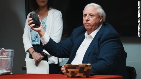 Gov. Jim Justice holds a lump of coal at a bill-signing ceremony for new coal-related legislation at John Amos Power Plant in Putnam County, West Virginia, in March.