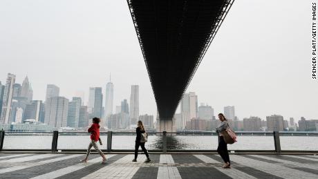 People walk through a Brooklyn Park in New York City on Tuesday morning. Air pollution levels were unhealthy for sensitive groups due to smoke from Canada&#39;s wildfires.