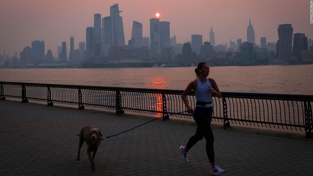 A woman jogs along the Hudson River as a smoky haze hangs over the New York City skyline shortly after sunrise on June 7.