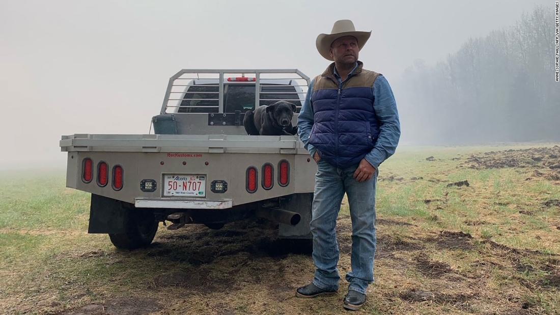BJ Fuchs, a farmer who has lost some land and had to move his cattle due to the wildfires, stands in Shining Bank, Alberta, on May 11.