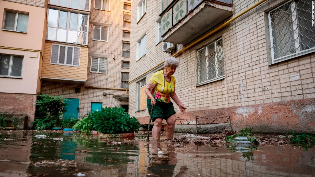 Local resident Oleksandra walks around her house on a flooded street in Kherson.